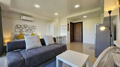a living room with a couch and a table at Квартира in Ban Mai Salae