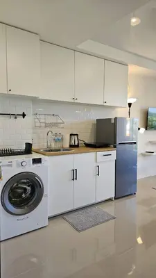 a kitchen with a washing machine and a washer at Квартира in Ban Mai Salae