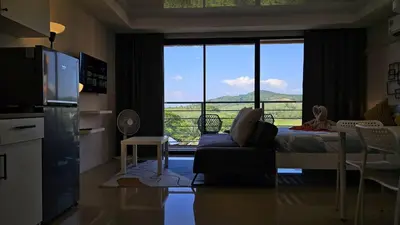 a living room with a couch and a large window at Квартира in Ban Mai Salae