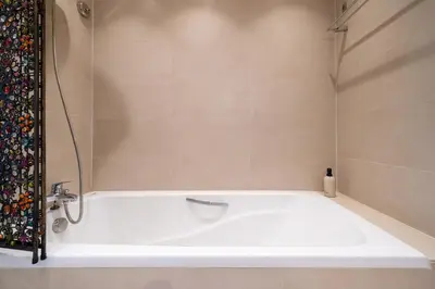 a white bath tub in a bathroom at Stylish Thai 2BR Condo Pool & Golf with Balcony in Laguna Phuket