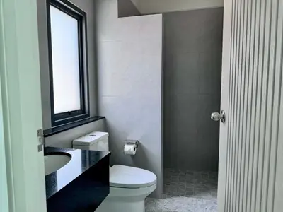a bathroom with a toilet and a sink and a window at Bay Sand Villa by Jai House Phuket in Ban Klang