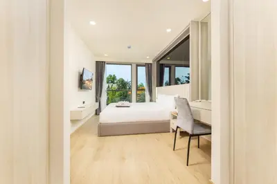 a bedroom with a bed and a desk and a chair at Suite Luna Pool and Gym Access The Ozone Condo in Bang Tao Beach