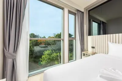 a bedroom with a bed and a large window at Suite Luna Pool and Gym Access The Ozone Condo in Bang Tao Beach