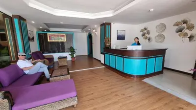 a man and a woman sitting at a bar in a lobby at Sereneburi Patong Hotel in Patong Beach