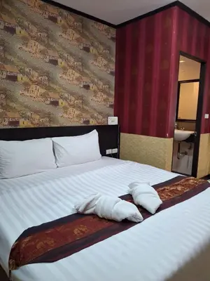 a bedroom with a bed with two towels on it at Sereneburi Patong Hotel in Patong Beach