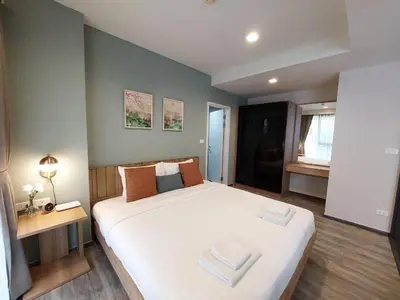a bedroom with a large bed with two towels on it at The Deck Patong in Patong Beach