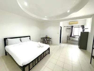 a bedroom with a white bed and a bathroom at Patong Canal Villa 108 in Patong Beach