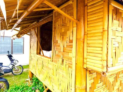 a wooden building with a motorcycle parked in the grass at Patong Canal House 1 in Patong Beach