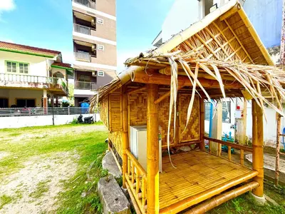 a small wooden house with a thatched roof at Patong Canal House 1 in Patong Beach
