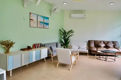 a living room with a couch and a table and chairs at Sweed Dee Love Hostel in Phi Phi Don
