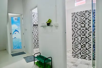 a white room with a glass door and a shower at Sweed Dee Love Hostel in Phi Phi Don