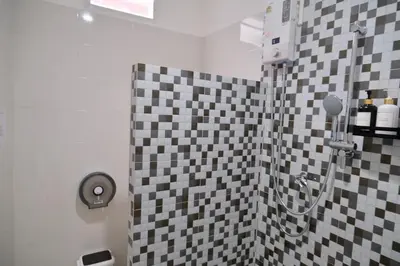 a bathroom with a shower with black and white tiles at Sweed Dee Love Hostel in Phi Phi Don
