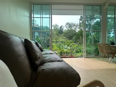 a leather couch in a living room with a large window at Sweed Dee Love Hostel in Phi Phi Don