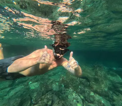 a man in the water giving the thumbs up at Sweed Dee Love Hostel in Phi Phi Don