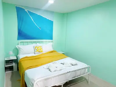a bedroom with a bed with a blue wall at \u82ad\u4e1c\u6d77\u6ee9\u5fc3\u6f84\u9152\u5e97 in Patong Beach