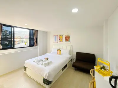 a bedroom with a bed and a chair in it at \u82ad\u4e1c\u6d77\u6ee9\u5fc3\u6f84\u9152\u5e97 in Patong Beach