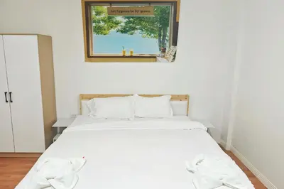 a white bed in a room with a window at \u82ad\u4e1c\u6d77\u6ee9\u5fc3\u6f84\u9152\u5e97 in Patong Beach