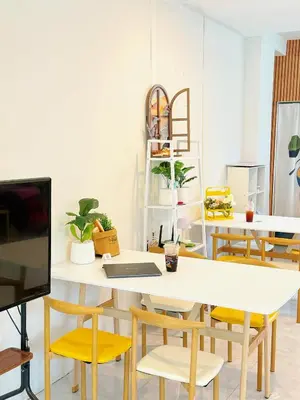 a dining room with a white table and yellow chairs at \u82ad\u4e1c\u6d77\u6ee9\u5fc3\u6f84\u9152\u5e97 in Patong Beach