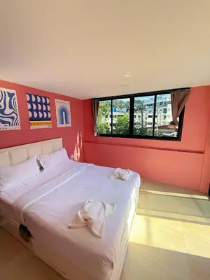 a bedroom with a white bed with red walls at \u82ad\u4e1c\u6d77\u6ee9\u5fc3\u6f84\u9152\u5e97 in Patong Beach