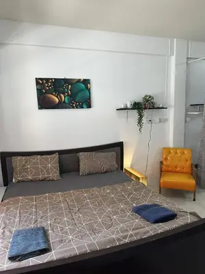 a bedroom with a large bed and a chair at Bestin Karon1 - 1 min from the beach, pet friendly TF in Karon Beach