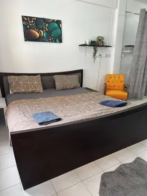 a large bed in a room with an orange chair at Bestin Karon1 - 1 min from the beach, pet friendly TF in Karon Beach