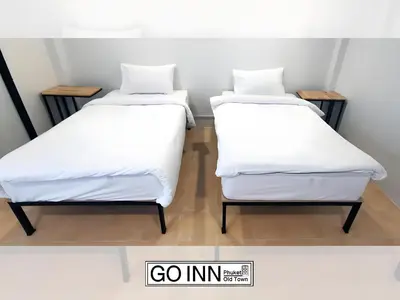 two beds sitting next to each other in a room at GO INN Phuket Old Town - โกอินน์ ภูเก็ต โอลทาวน์ in Phuket Town