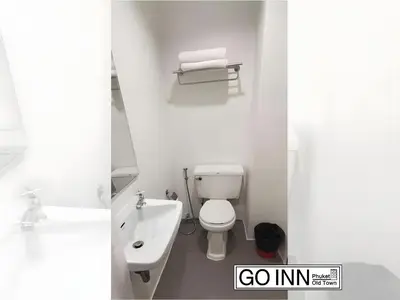 a white bathroom with a toilet and a sink at GO INN Phuket Old Town - โกอินน์ ภูเก็ต โอลทาวน์ in Phuket Town