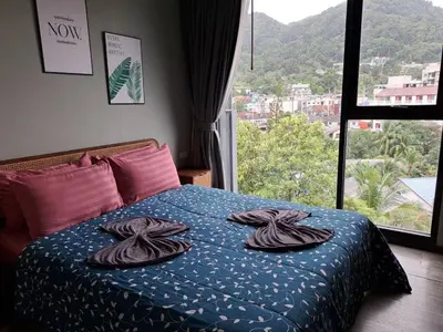 a bedroom with a bed with towels on it at The Deck Condo Patong Mountain View1 in Patong Beach