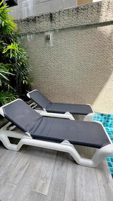 two empty lounge chairs sitting next to a pool at Beachfront Family Pool 2 Bed Room Patong Phuket in Patong Beach