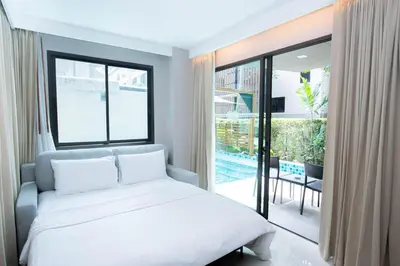 a bedroom with a bed and a large window at Beachfront Family Pool 2 Bed Room Patong Phuket in Patong Beach