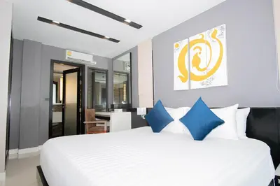 a bedroom with a large white bed with blue pillows at Beachfront Family Pool 2 Bed Room Patong Phuket in Patong Beach