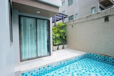 a swimming pool in front of a building at Beachfront Family Pool 2 Bed Room Patong Phuket in Patong Beach