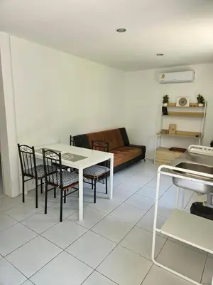a living room with a table and chairs and a couch at Bestin Karon 2 in Karon Beach