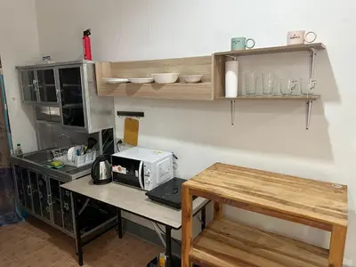 a kitchen with a table and a microwave on a counter at Bestin Karon 2 in Karon Beach