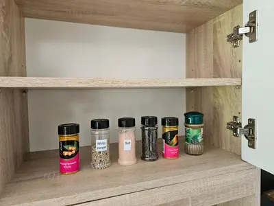 a shelf with four spice jars in a cupboard at Bestin Karon 2 in Karon Beach