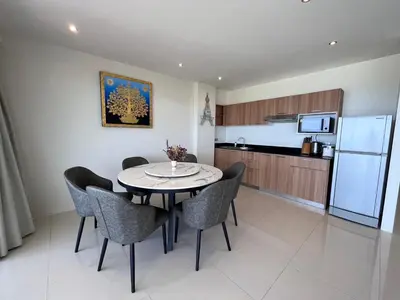 a kitchen and dining room with a table and chairs at Sunset Plaza Karon Seaview in Karon Beach
