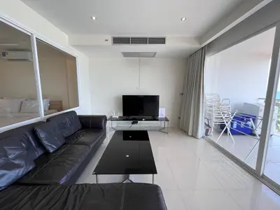 a living room with a couch and a tv at Sunset Plaza Karon Seaview in Karon Beach