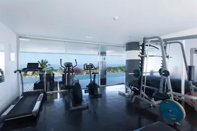 a gym with a view of the water at Sunset Plaza Karon Seaview in Karon Beach