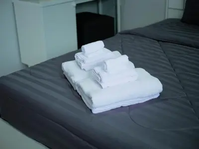 a pile of towels sitting on top of a bed at Borrii House โบ ลี่ เฮาท์ in Layan Beach