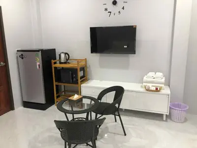 a living room with two chairs and a table and a tv at Borrii House โบ ลี่ เฮาท์ in Layan Beach