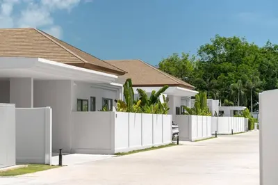a white fence in front of a house at Tropical Family Pool Villa - Bang Tao in Laguna Phuket