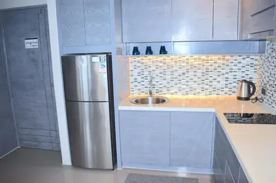 a kitchen with a stainless steel refrigerator and a sink at Oasis in CityGate 1BR Suite in Kamala Beach