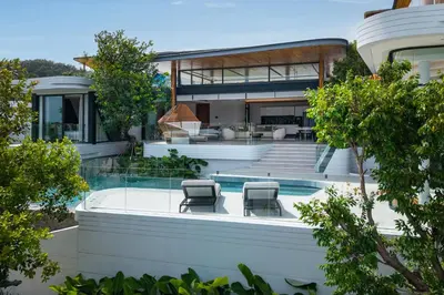 a house with a swimming pool and two chairs at Villa Zavaya 360° View Luxury Retreat With Pool in Layan Beach