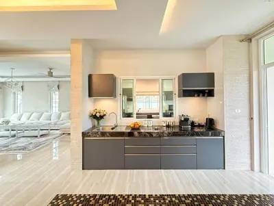 a kitchen with a sink and a living room at Kamala Beach Phuket - 4BR Private Luxury Pool Villa with Maid in Kamala Beach