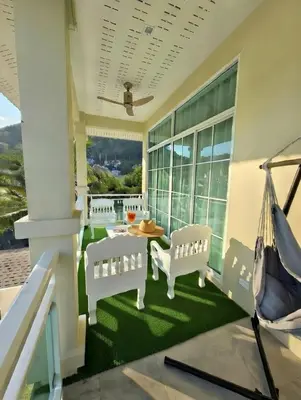 a porch with white chairs and a table with a view at Kamala Beach Phuket - 4BR Private Luxury Pool Villa with Maid in Kamala Beach