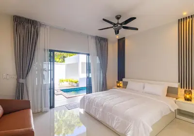 a bedroom with a bed and a ceiling fan at Villa Junia - Quiet 3-bedroom Pool Villa in Ban Saiyuan (1)