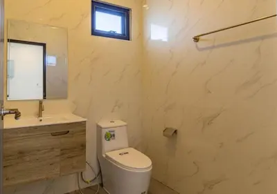 a bathroom with a toilet and a sink and a mirror at Villa Junia - Quiet 3-bedroom Pool Villa in Ban Saiyuan (1)