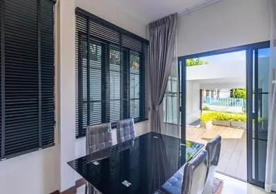 a dining room with a glass table and chairs at Villa Junia - Quiet 3-bedroom Pool Villa in Ban Saiyuan (1)