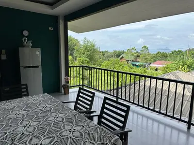 a balcony with a table and chairs and a view at Nankanok Resort in Ko Yao Noi