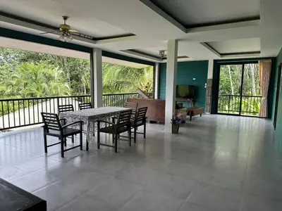 a dining room with a table and chairs on a balcony at Nankanok Resort in Ko Yao Noi